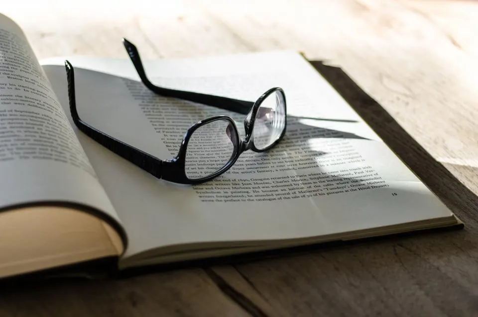 Reading glasses resting on an open book