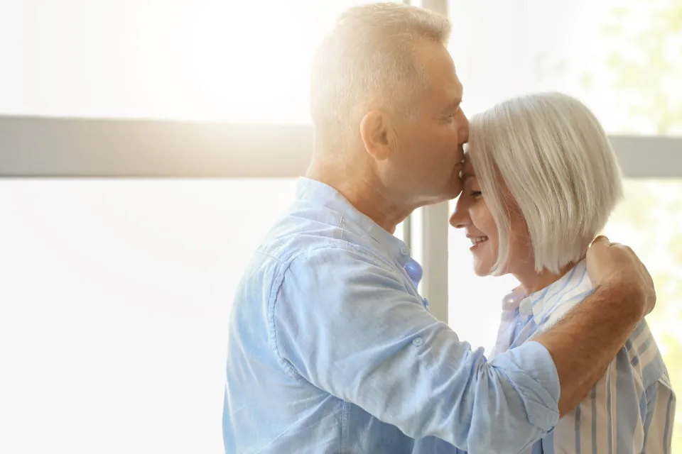 An older couple smiling together at home