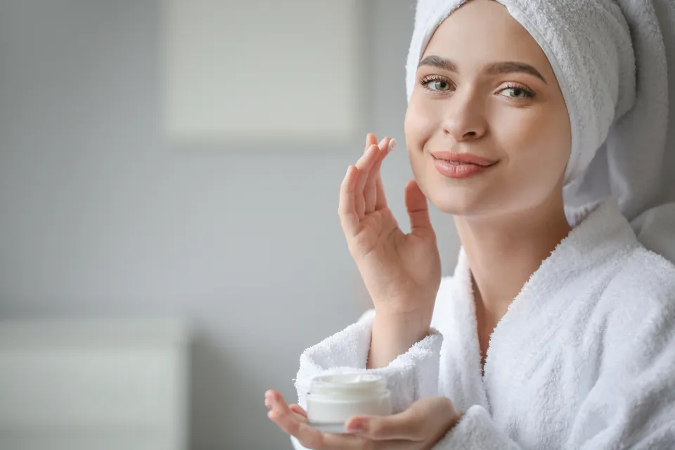 A woman applying face cream